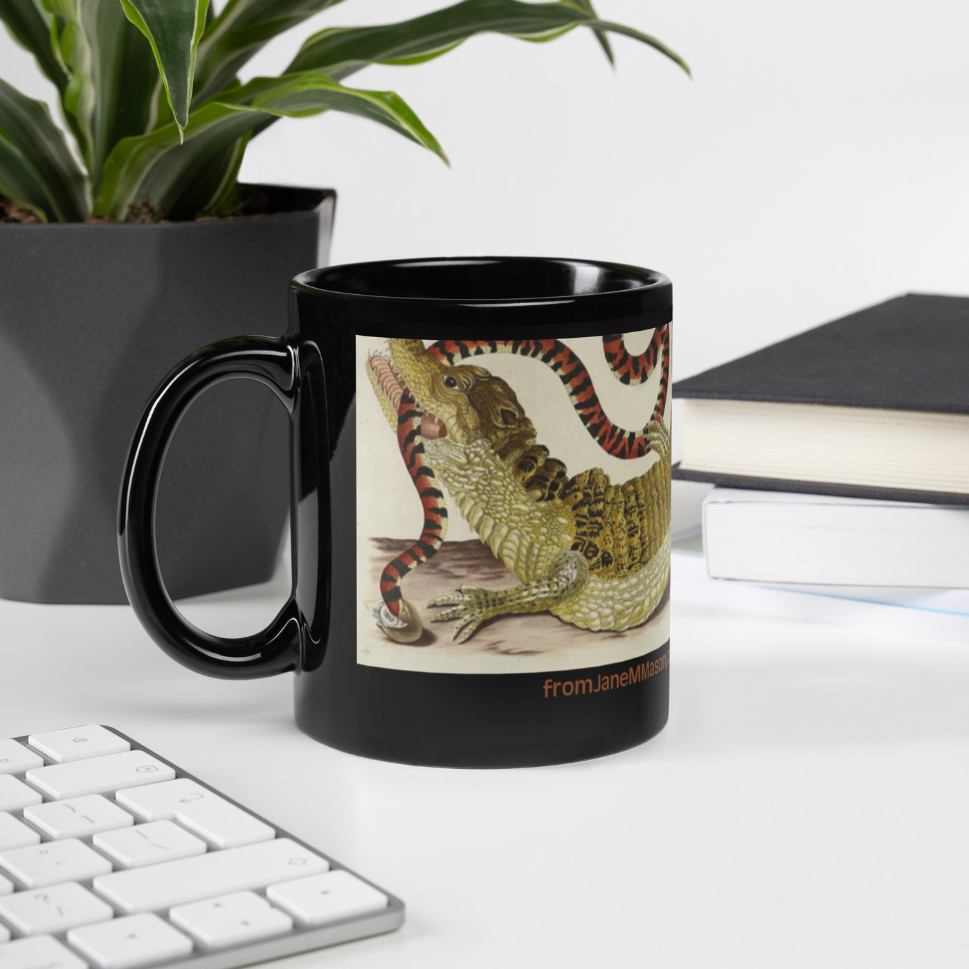  A black mug with black interior featuring an alligator wrestling with a large snake. Message is: Kindly wait until after my coffee. The painting is by Maria Sibylla Merian,  approx. 1650. 